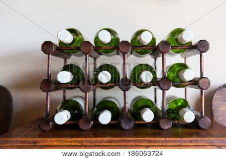 storage, winery and alcohol drinks concept - white wine bottles stored on wooden rack