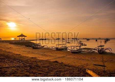 Traditional Balinese Boats And Pavilion In Sanur Beach In The Morning At Dawn, Bali, Indonesia.
