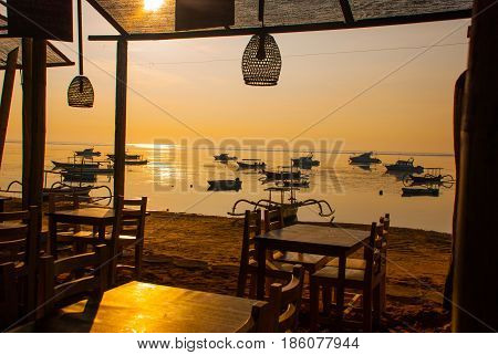 Beautiful Beach With A Cafe In Sanur With Local Traditional Boats. Bali, Indonesia. Dawn.