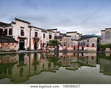 HONGCUN, CHINA - APRIL 20, 2014: Tourist walking around Moon Lake. Hongcun is ancient village in Anhui Province near the southwest of Mount Huangshan.