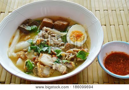 boiled Chinese pasta with pork and entrails topping creamy egg yolk in soup