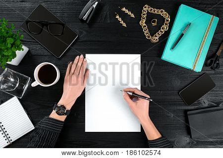 View from above with copy space office table , notebook with cup of coffee and Smart Phon. Woman holding a pen in her hands