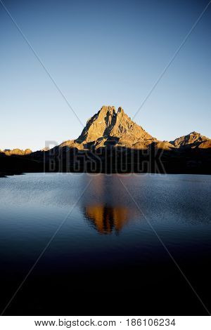 Midi Dossau Peak reflected in Ayous lake. Ossau Valley, Pyrenees National Park, Pyrenees, France.