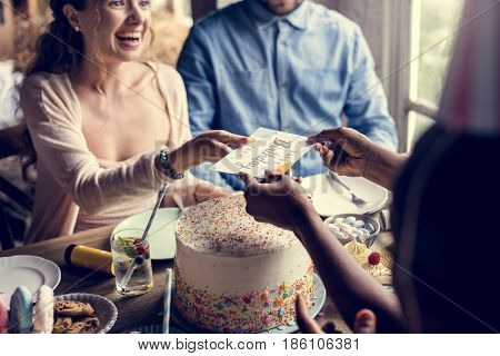 People celebrate birthday party with cake and card