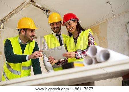 Group Of Young Arhitects With Tablet On Construction Site