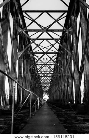 Black and white old industrial railway railroad iron bridge center perspective in night