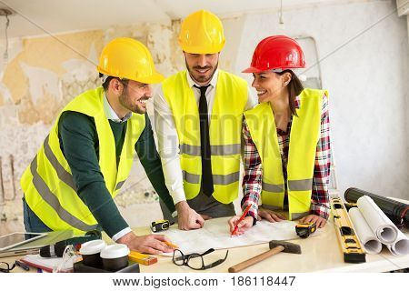 Three Arhitects Working Together On Construction Site Project