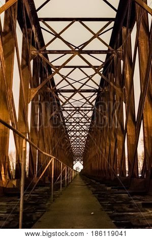 Old industrial railway railroad iron bridge center perspective in night