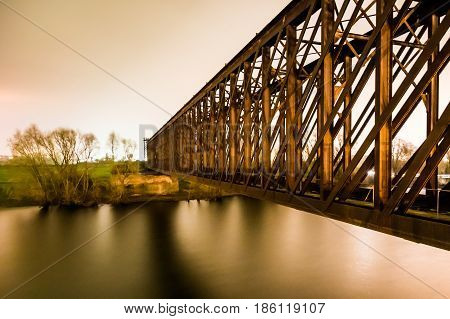 Old industrial railway railroad iron bridge in the night
