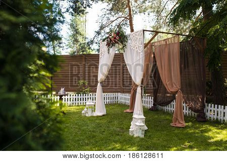 Beautiful Wedding Ceremony Outdoors. Decorated Chairs Stand On The Grass. Wedding Arch Made  Flowers
