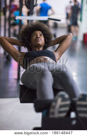 young fit african american woman doing sit ups in fitness studio at the gym.Abdominal exercises Sit up