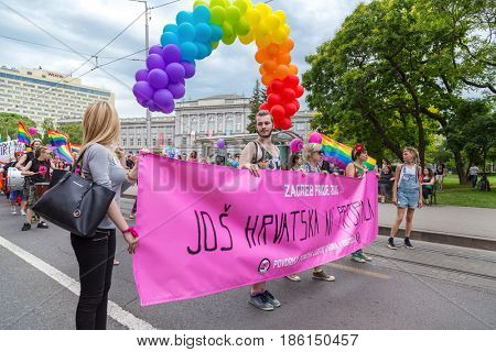 ZAGREB, CROATIA - JUNE 11, 2016: 15th Zagreb pride. LGBTIQ activists holding pride banner.