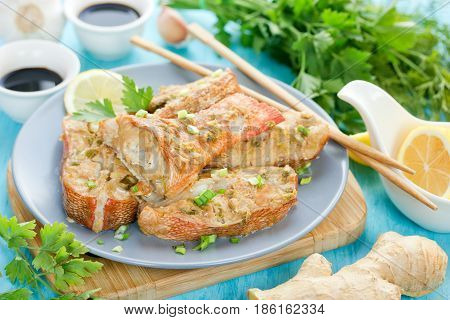 Steamed snapper (pacific ocean perch sea bass ruby perch) with soy sauce lemon ginger and parsley in Asian style. Healthy cooking