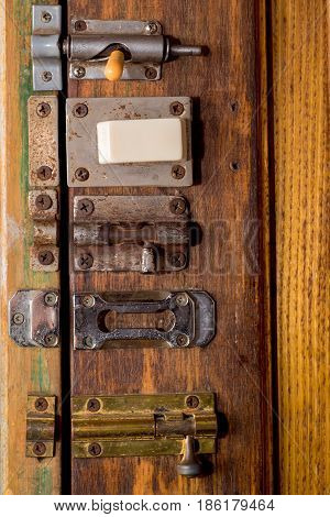 Many variuos sliding bolts on wooden door