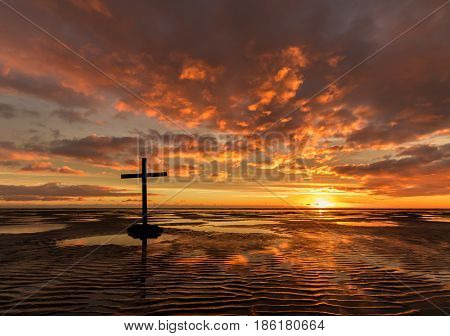 Black cross on a beach with the tide out pools of water gives a wonderful texture reflection.