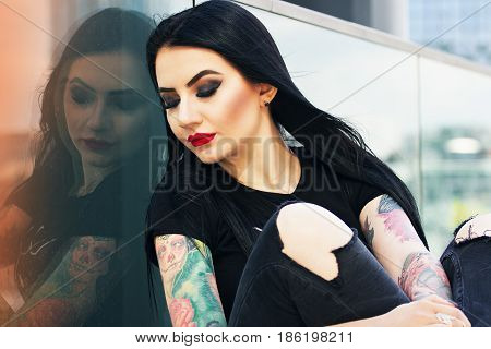 Tattoo Fashion. Portrait Of Fashionable Tattoed Hipster Girl With Red Lips Posing Against Urban Back