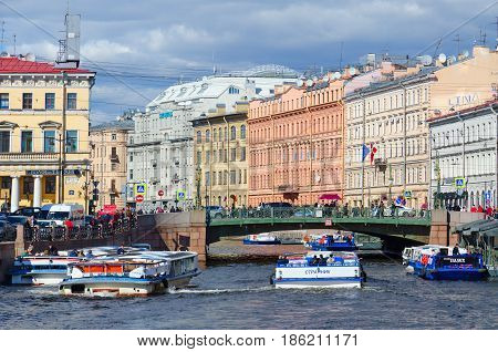 SAINT PETERSBURG RUSSIA - MAY 3 2017: Excursion boats on Moika River near Green Bridge in St. Petersburg. Unidentified tourists are visiting sights during walk along rivers and canals of city