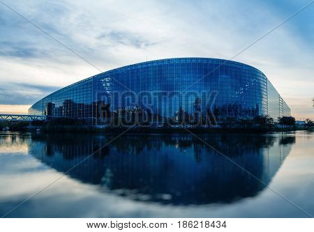 STRASBOURG FRANCE - MAR 31 2017: South facade of the European Parliament in Strasbourg with the intersection of the Ill and Marne-Rhine Canal at dusk. The European Parliament (or EU Parliament or the EP) is the directly elected parliamentary institution o