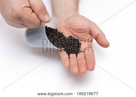 Plastic Pellets Spilled Out Of The Measuring Cup On A Man's Hand. Colorant For Plastics. Pigment In 