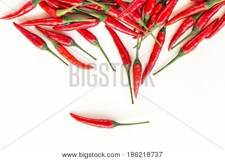 red hot chili peppers, popular hot spices, food making concept - beautiful handful of fresh red spicy peppers, scattered pods on a white background, top view, flat lay.