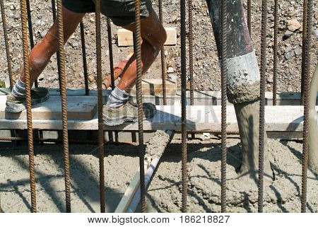 Bissone Switzerland - 10 August 2010: Street worker pouring cement with a pump into a highway construction