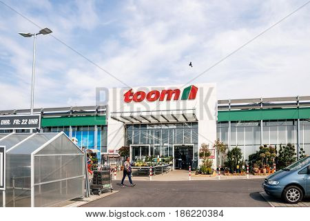 FRANKFURT GERMANY - APR 1 2017: Black ethnicity woman walking to the entrance of TOOM the German DIY-store chain offering home improvement and do-it-yourself goods - customers buying goods selecting the best tools