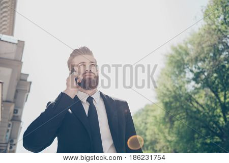 Successful Young Red Bearded Entrepreneur Is Having Nagotiation On His Phone Outside In A Sunny Day.