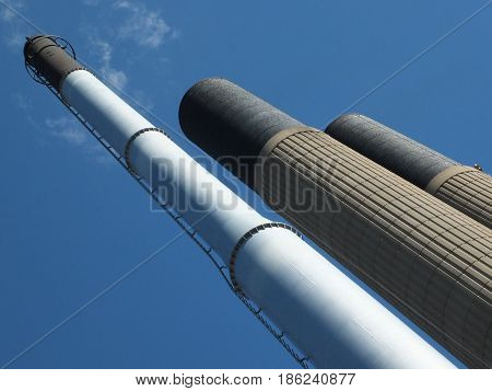 tall industrial chimneys in concrete and steel with blue sky