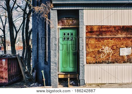 A broken green door in the ghettos.
