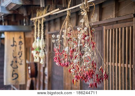 Traditional Japanese red chillies hanging from thatched roof