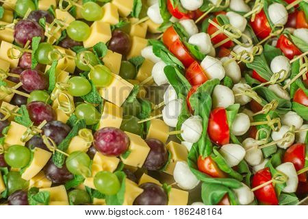 appetizer canape cheese with white grapes on bamboo skewers