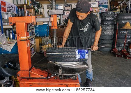Labuan,Malaysia-May 9,2017:Car tire service mechanic changing car wheel before makes computer wheel balancing on special equipment machine tool in auto repair service in Labuan,Malaysia.