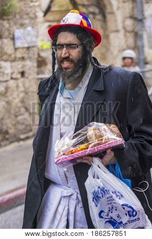 JERUSALEM - MARCH 13 : Ultra Orthodox man holding Mishloach Manot during Purim in Mea Shearim Jerusalem on March 13 2017 Mishloach Manot is traditional food gifts given during Purim