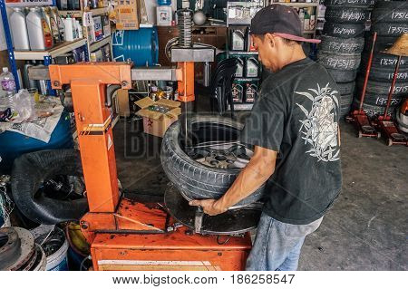 Labuan,Malaysia-May 9,2017:Car tire service mechanic changing car wheel before makes computer wheel balancing on special equipment machine tool in auto repair service in Labuan,Malaysia.