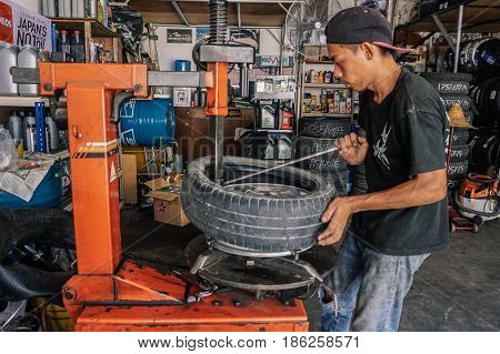 Labuan,Malaysia-May 9,2017:Car tire service mechanic changing car wheel before makes computer wheel balancing on special equipment machine tool in auto repair service in Labuan,Malaysia.