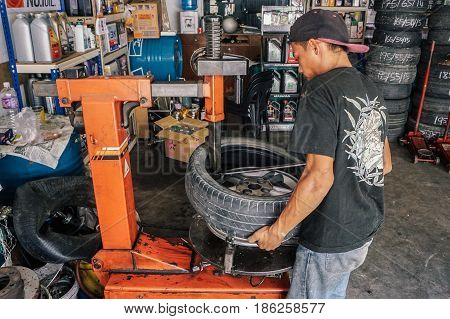 Labuan,Malaysia-May 9,2017:Car tire service mechanic changing car wheel before makes computer wheel balancing on special equipment machine tool in auto repair service in Labuan,Malaysia.
