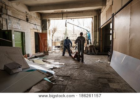 Workers unloading palleted aerated concrete blocks shot in studio being repaired