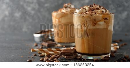 Cold frappe coffee with cream on a gray background