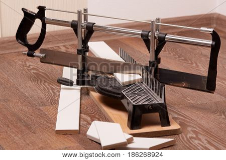 Handsaw and mitre box on linoleum floor. Home repair. Carpentry Tools.