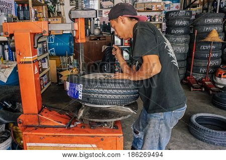 Labuan,Malaysia-May 9,2017:Car tire service mechanic changing car wheel before makes computer wheel balancing on special equipment machine tool in auto repair service in Labuan,Malaysia.