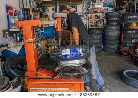 Labuan,Malaysia-May 9,2017:Car tire service mechanic changing car wheel before makes computer wheel balancing on special equipment machine tool in auto repair service in Labuan,Malaysia.