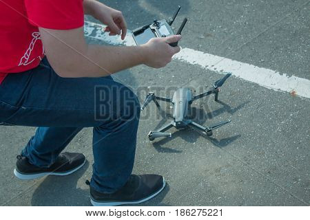The guy starts a quadrocopter with an asphalt surface. Preparation for start, calibration of navigation systems