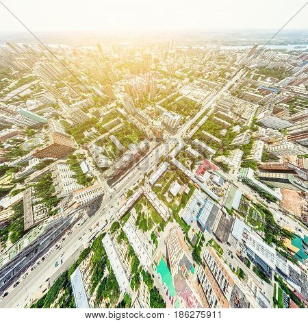 Aerial city view with crossroads and roads, houses, buildings, parks and parking lots, bridges. Helicopter drone shot. Wide Panoramic image.