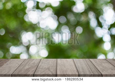 Empty wooden table top and sunny blurred bokeh background for product displa