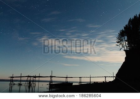 Night view of the pier by the river and the starry sky