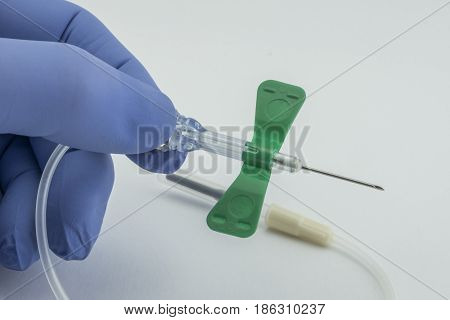 Nurse With Blue Glove Holding A Catheter Of Venipuncture