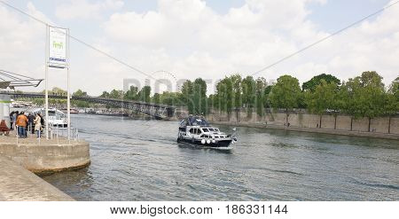 ParisFrance- April 292017:People are waiting for the ship on the Port de Solferino.On the Seine floats the boat