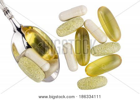 Vitamin complex omega 3 glucosamine capsules multivitamin supplements in the spoon isolated on white background top view.