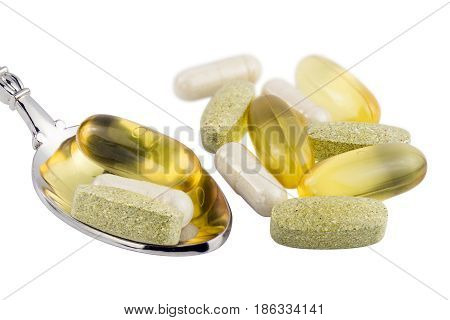 Vitamin complex omega 3 glucosamine capsules multivitamin supplements in the spoon isolated on white background.