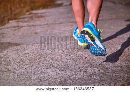 Running athlete during training outdoors in the summer on a sunny day.
